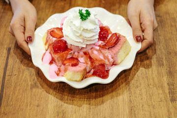 dessert with strawberry  bakes toast bread melting ice-cream and mint decoration on wooden dark background