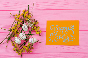 Happy Easter background with spring plants. Nest from styrofoam festive eggs, pussy willow, flower,...