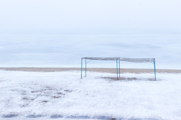 Empty beach in spring on the banks of the river, shelter from the sun. Foggy