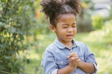 little girl praying. kid prays. Gesture of faith.Hands folded in prayer concept for...