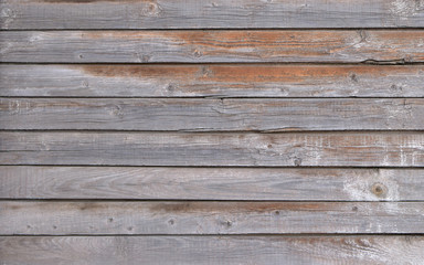 The unique texture of time-aged wooden boards with yellowish stains on an uneven surface