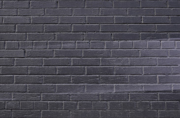 Texture of black painted brick wall close-up with a gray gradient from edge to center