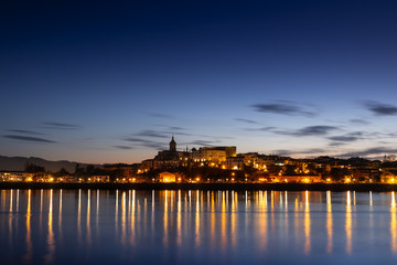 The lights of the city of Hondarribia are reflected in the sea water at night, Euskadi