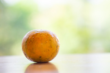 Fototapeta premium Orange fruit on wooden table in the garden background, Close up shot, Selective focus