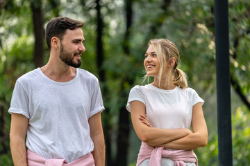 Obraz premium Man and Woman looking each other smiling and walking together in the public park