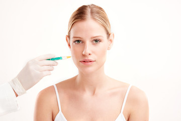 Close-up portrait of young woman having botox treatment