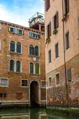 Fototapeta na wymiar Gondola in narrow canal in Venice, Italy