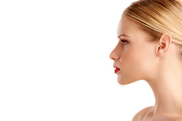 Close-up profile face of beautiful young woman posing at isolated white background