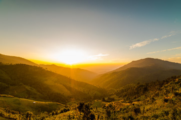 Obraz premium The sun sets behind the mountains, the scenic spot.