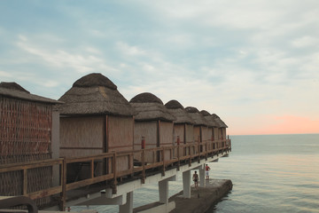 Bungalows for relaxation and privacy on the sea at sunset.