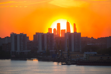 Fototapeta na wymiar Sunrise at the city. Silhouette of buildings.