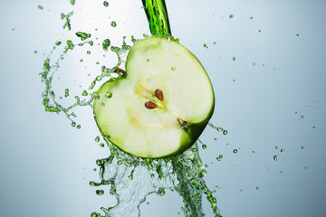 Apple splashing juice, water, on a white background.