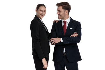 couple in business suits standing together with arms crossed