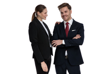 couple in business suits standing together with arms crossed