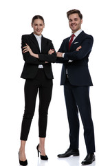 couple in business suits standing together with arms crossed