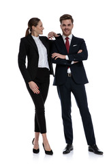 couple in business suits standing with elbow lean on shoulder