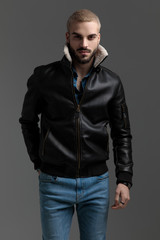 blonde guy in blue jeans and leather jacket walking