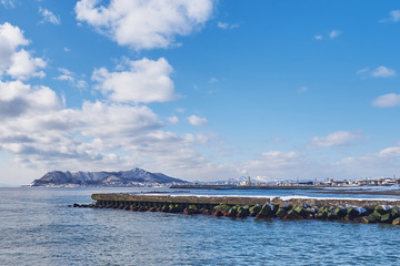 Beautiful landscape scenic of Hakodate mountain at the end of Matsukura river to ocean in Hakodate city, Hokkaido, Japan.