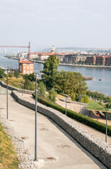 Bilbao, Spain-September 2018. River of the city with people in the shore. Describe the city life.
