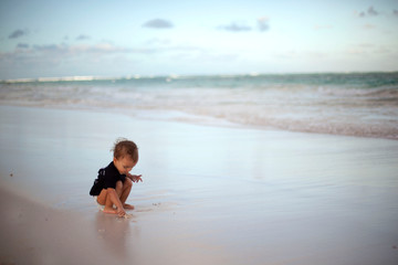 Cute little baby girl walking on the beach