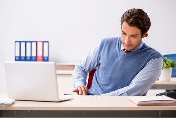 Young handsome employee working in the office 