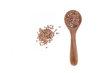 Brown flax seed in spoon top view on white background.