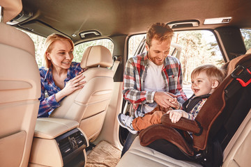 Travel is like an endless university. You never stop learning. Parents playing with their kid inside a car. Family road trip