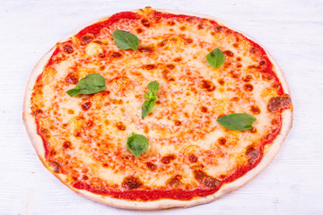 Margarita pizza under cheese with tomato sauce