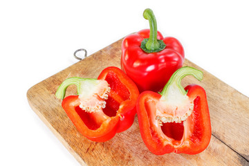 red bell pepper cut in half on wooden cutting board background.