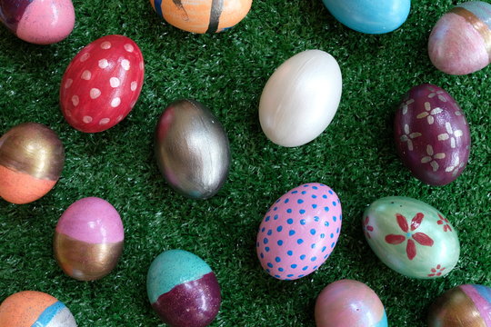 Many colorful fancy easter egg painted on green lawn background, festive holiday event concept