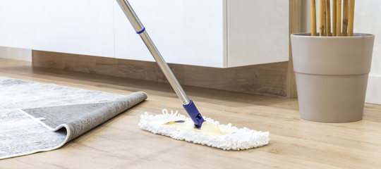Wooden floor with white mop, cleaning service concept