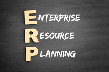 Fototapeta premium Wooden alphabets building the word ERP - Enterprise Resource Planning acronym on blackboard