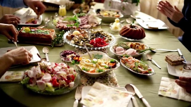 People around table during easter brekfast: focus on hands. 