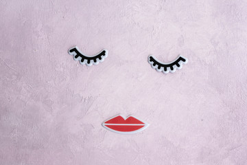 Creative woman face made of eyelashes, and lips. Minimal beauty concept. Pink background, fashion flat. banner