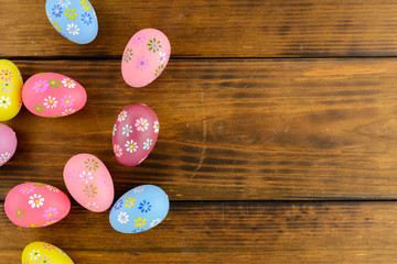 Colorful easter eggs on a brown wooden table. Top view, copy space.