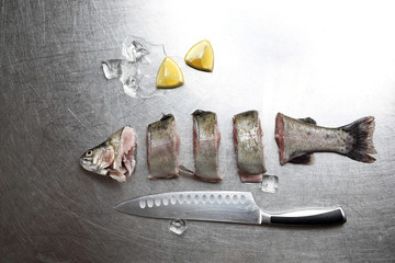 Świeża ryba pocięta na kawałki na srebrnym blacie.