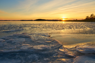 Obraz premium Frozen beach and icy sea on a sunset in Ruissalo, Finland. 