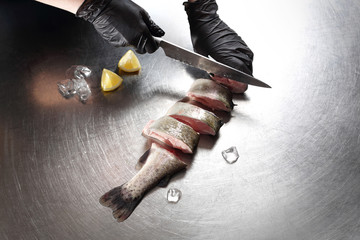 Świeża ryba w kuchni. Kobieta oprawia pstrągi  © foodandcook