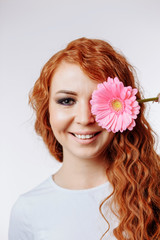 Naklejka premium Young woman holding flower over her face