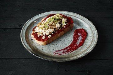 Beetroot humus with toast, chickpea and sesame seeds over wooden surface