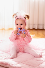 Fototapeta premium Baby girl chewing a rattle