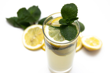 a glass of fresh lemonade, against a background of lemons and mint, isolated on a white background. top view.