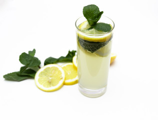 a glass of fresh lemonade, against a background of lemons and mint, isolated on a white background.