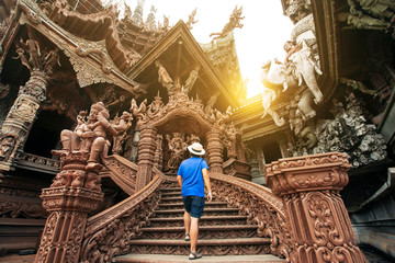 A man tourist is sightseeing inside the Ancient wooden Sanctuary of Truth in Pattaya, Thailand. - obrazy, fototapety, plakaty