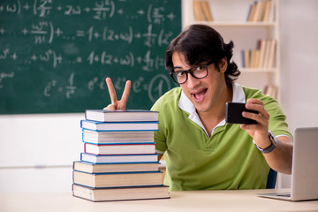 Handsome student in front of chalkboard with formulas 