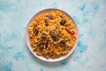 Uzbek pilaf in a plate on a blue background. 