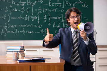 Young male math teacher in classroom 