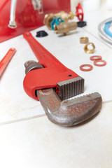 Plumbing wrench on the bathroom ceramic floor.