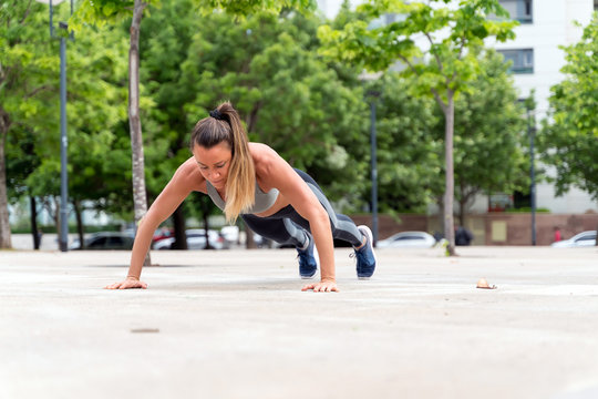 An athletic woman doing push ups in the park © Spectral-Design