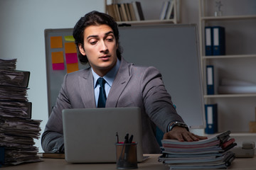 Young male employee working late at office 